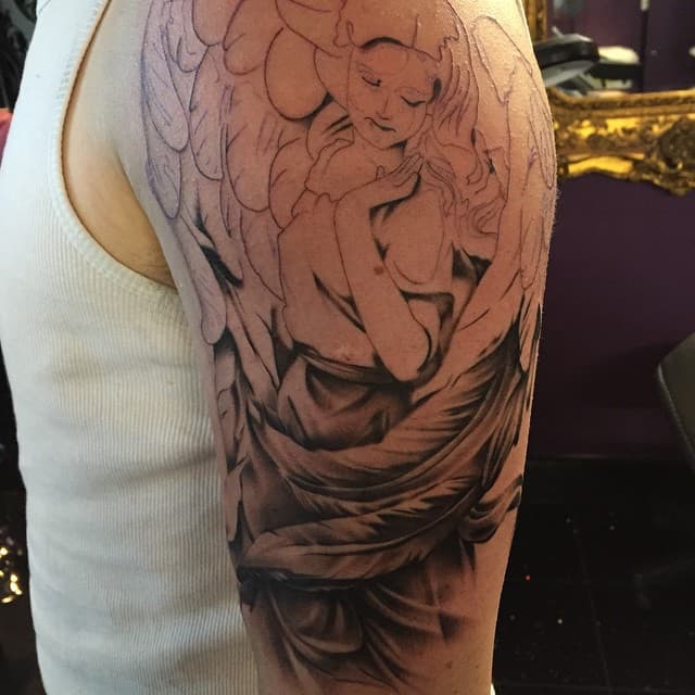 Black and grey half sleeve tattoo on an arm