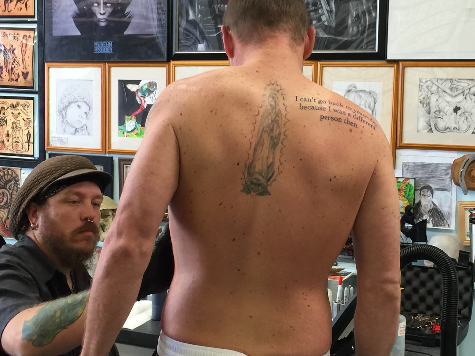 Tattoo artist finishing a back tattoo before aftercare begins